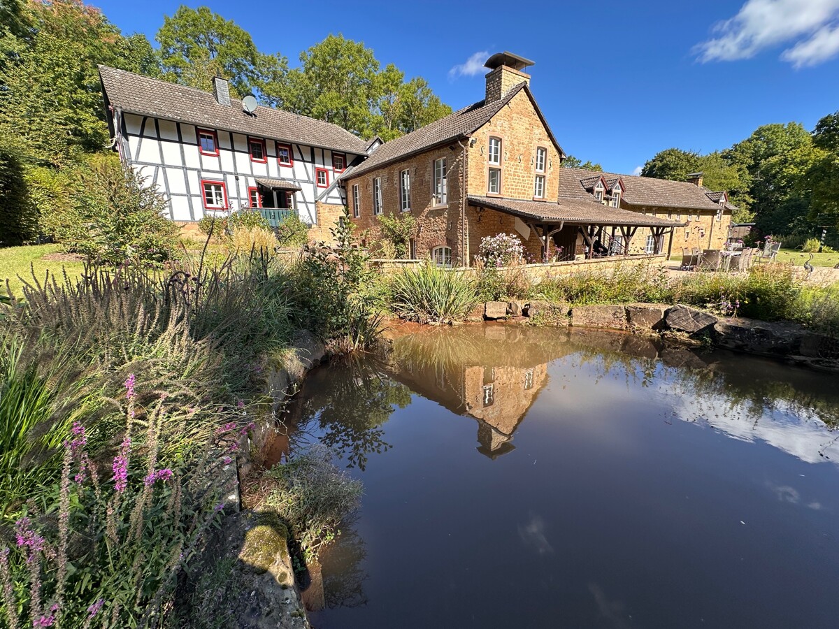 Blick über den Hausteich auf den Wohntrakt